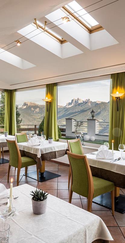 Speisesaal mit Blick auf die Dolomiten und den Garten