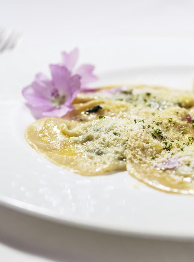 Mezzelune ripiene con spinacci e garnite con burro fuso e parmigiano